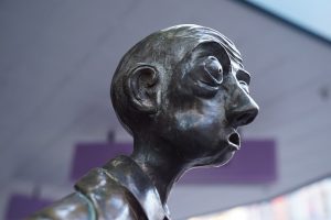Une statue d'un homme, bouche ouverte, sans mot