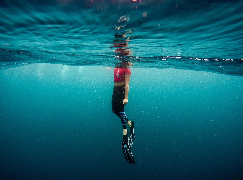 Une nageuse, vue sous l'eau, la tête hors de l'eau.
